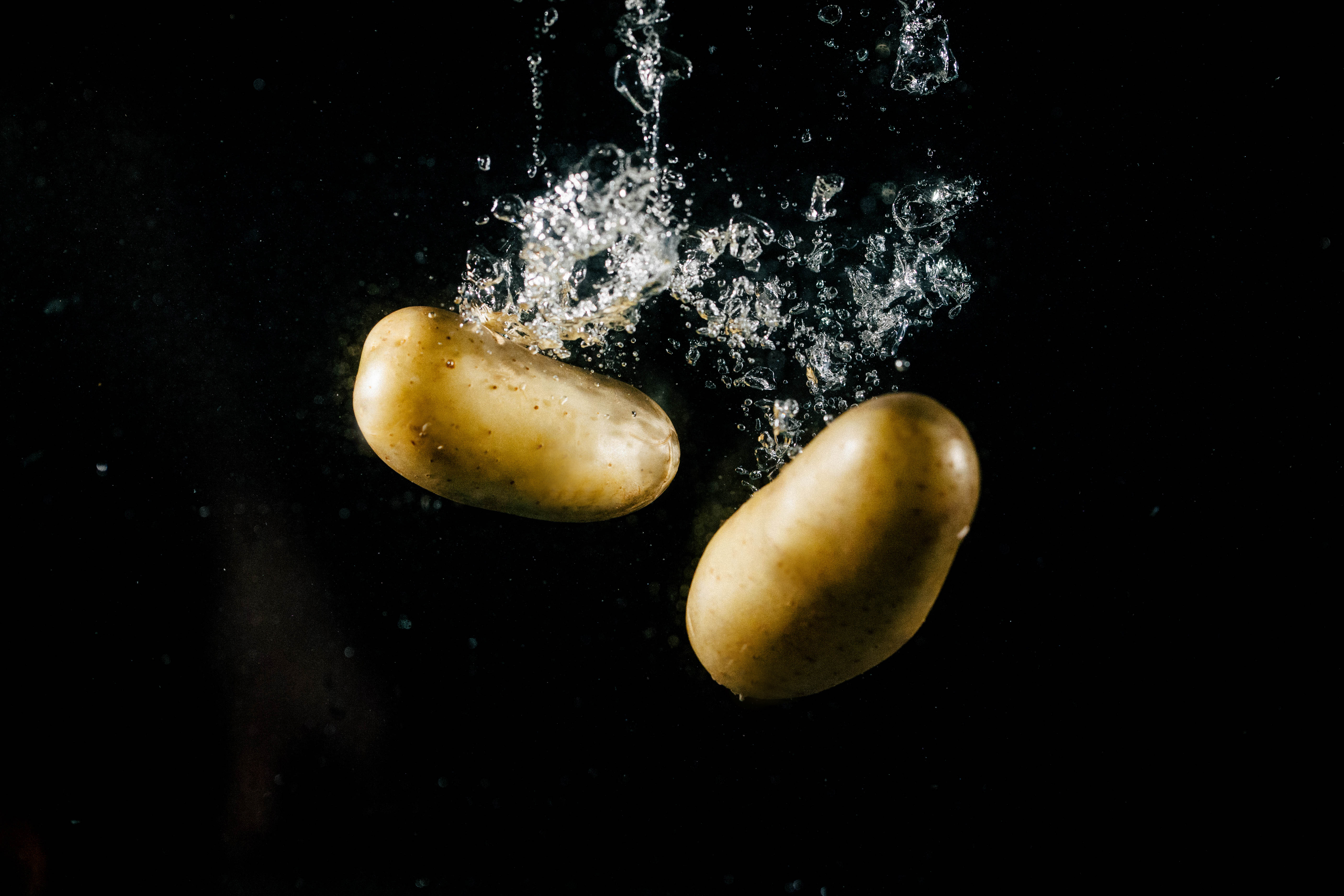 Two large potatoes fall in water and make bubbles. Credit v.ivash.